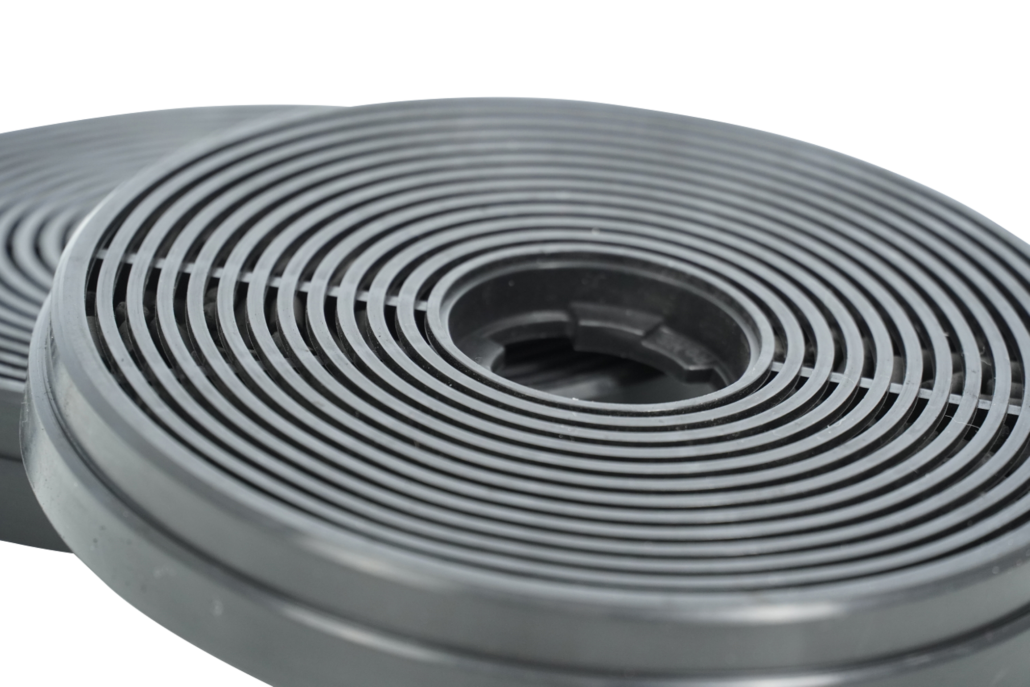 Two cylindrical black carbon filters with concentric ridges are displayed against a white background.