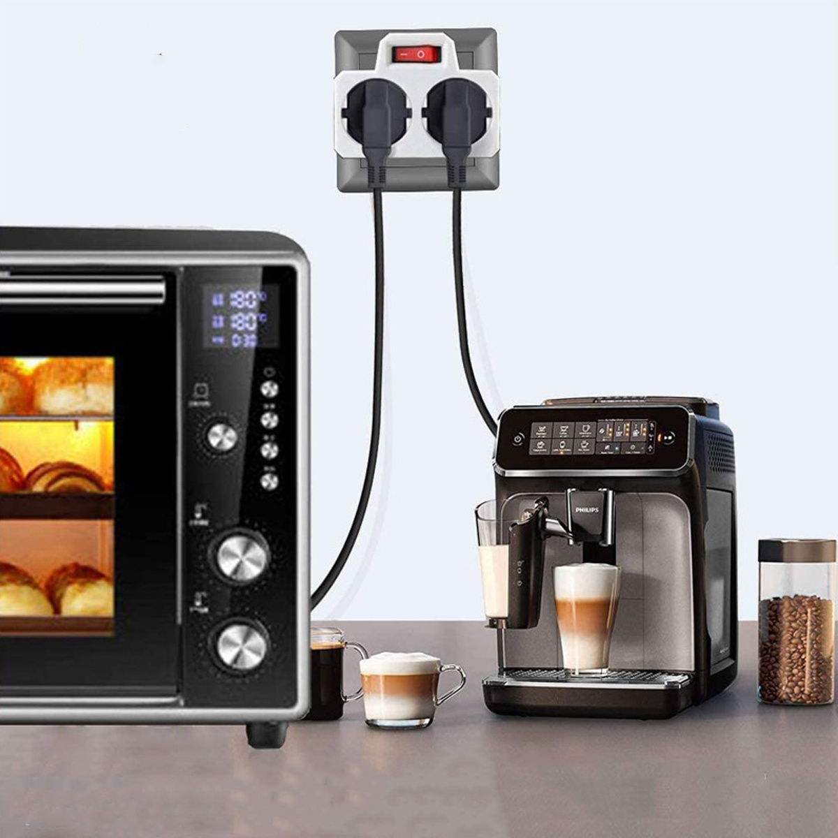 Eine Steckdosenleiste mit zwei eingesteckten Steckern. Sie befindet sich zwischen einer Mikrowelle und einer Kaffeemaschine.