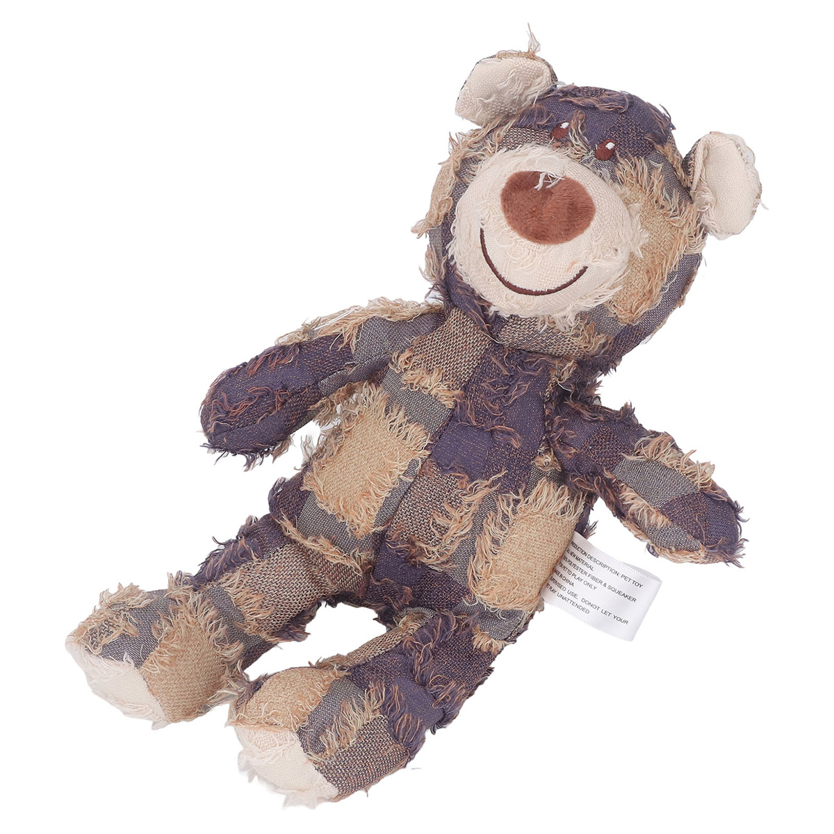 Teddybär-Spielzeug mit geflicktem Design, liegt auf weißer Oberfläche.