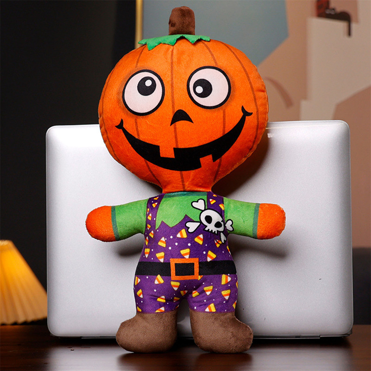 Kürbisköpfiges Plüschtier mit lächelndem Gesicht, das ein Halloween-Kostüm trägt.