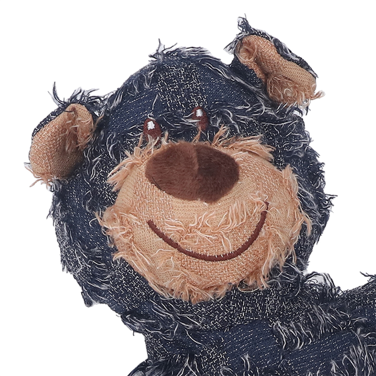 Nahaufnahme eines Plüschbären mit jeansartigem blauem Fell, einer beigen Schnauze und einem gestickten Lächeln.