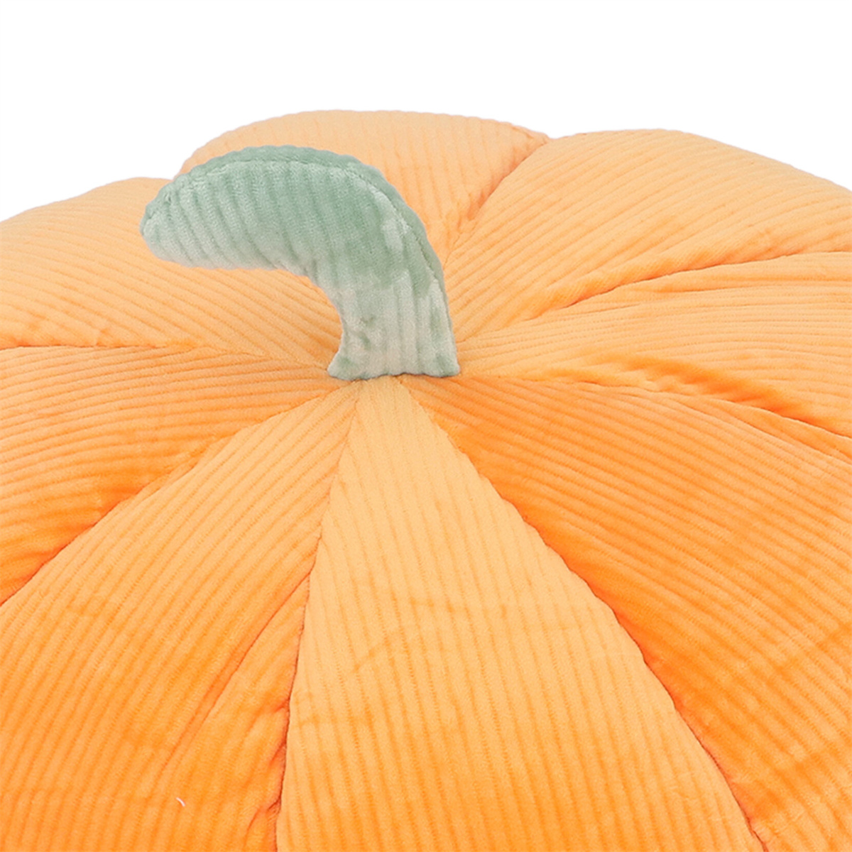 Nahaufnahme eines orangefarbenen, kürbisförmigen Kissens mit grünem Stiel.