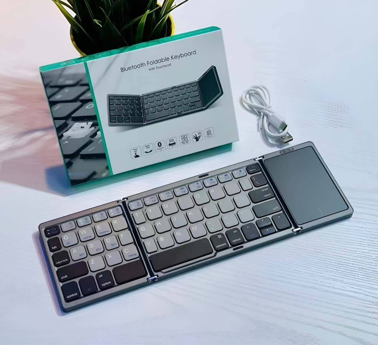 Schwarz-graue faltbare Tastatur mit Touchpad und Box.