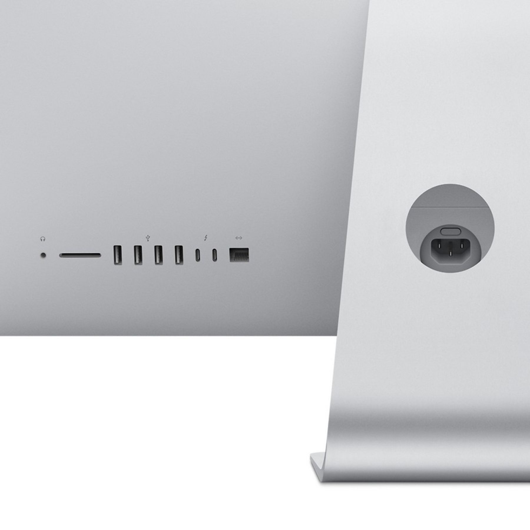 Parte trasera de computadora plateada con puertos y entrada de alimentación, y el soporte.
