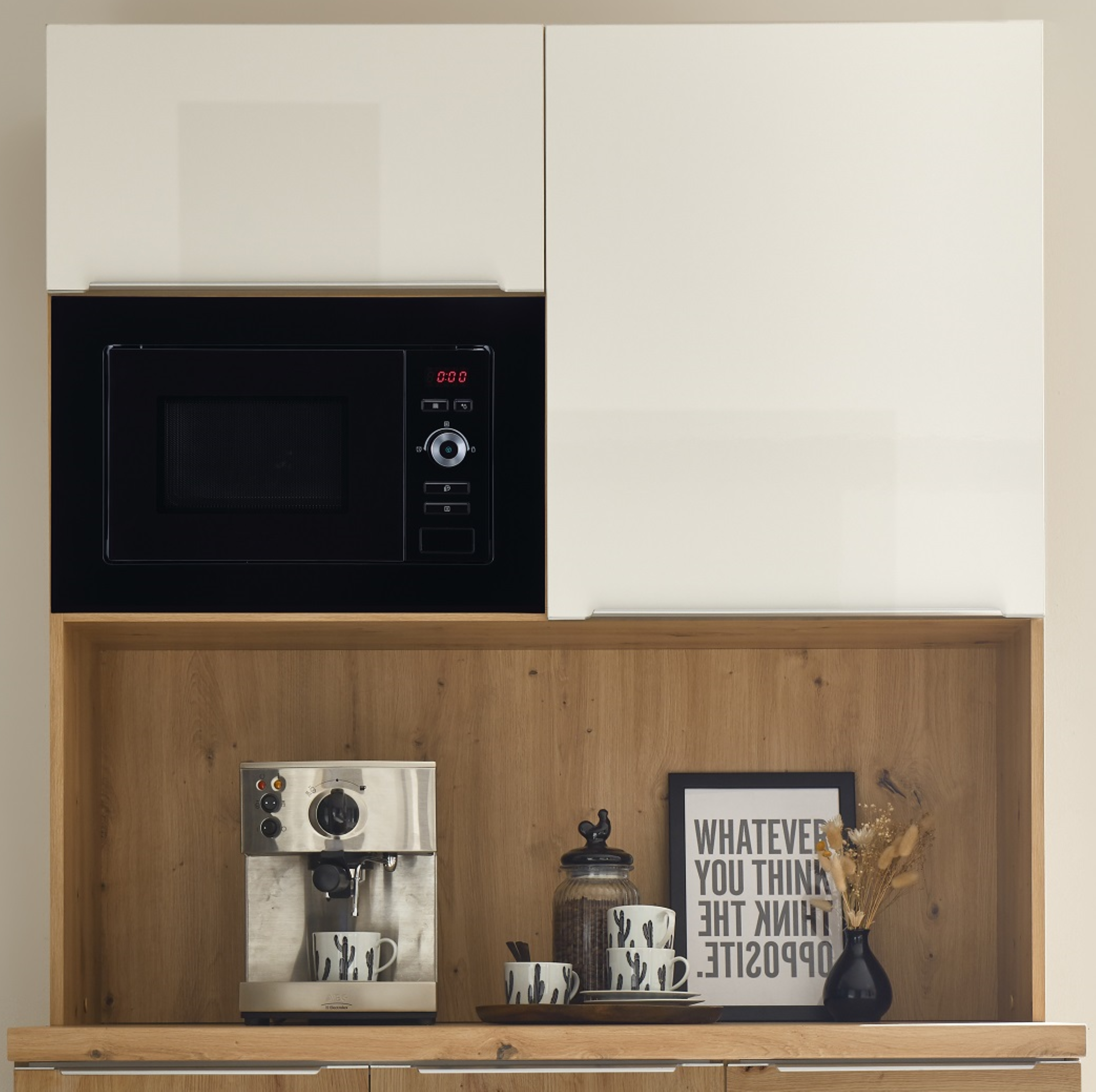 Kitchen cabinet with a microwave. Below, a coffee machine, cups, and decor are on a wooden shelf.