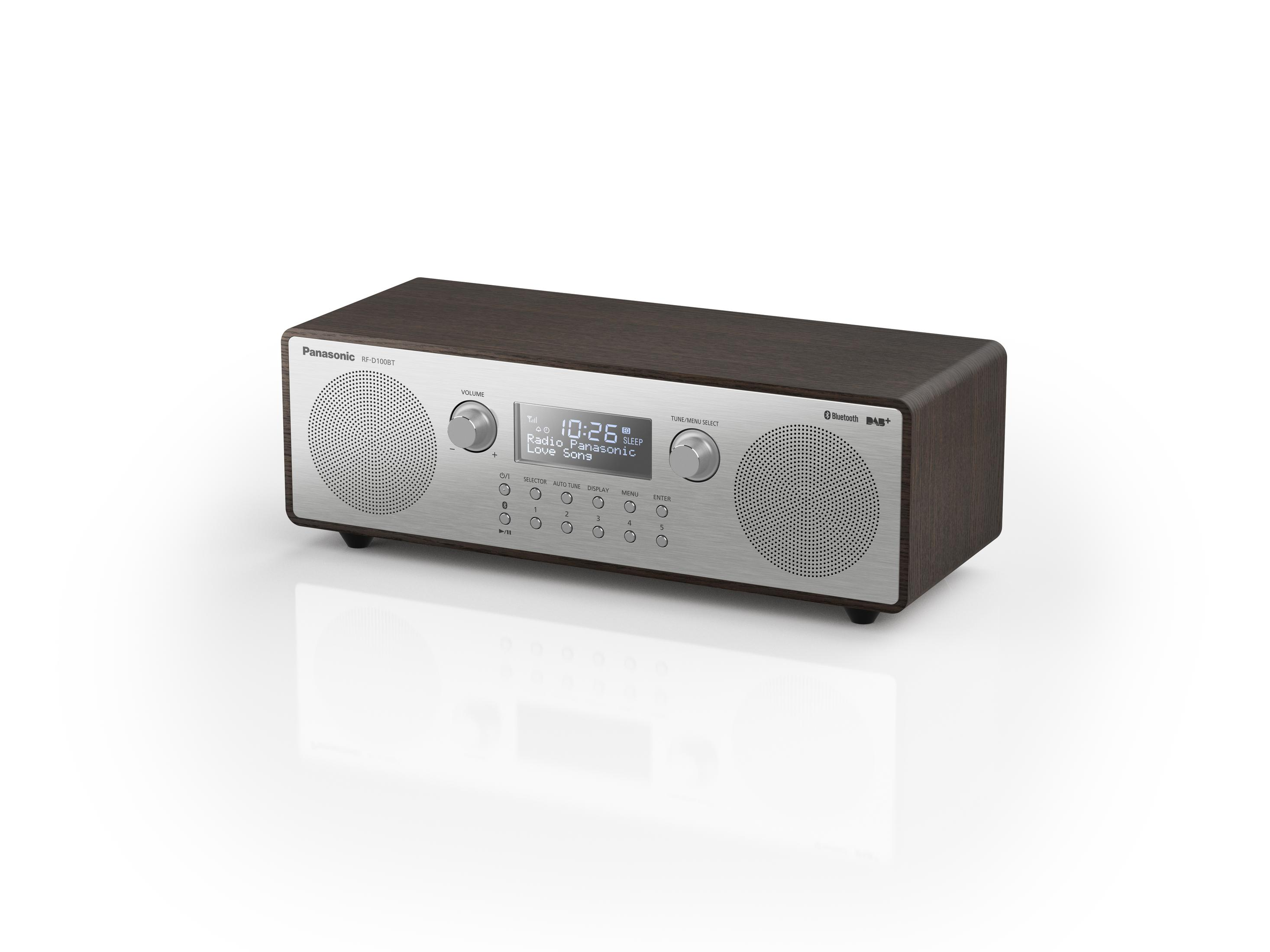 Drewniane radio ze srebrnym przodem. Wyświetla godzinę i ma dwie kratki głośnikowe.