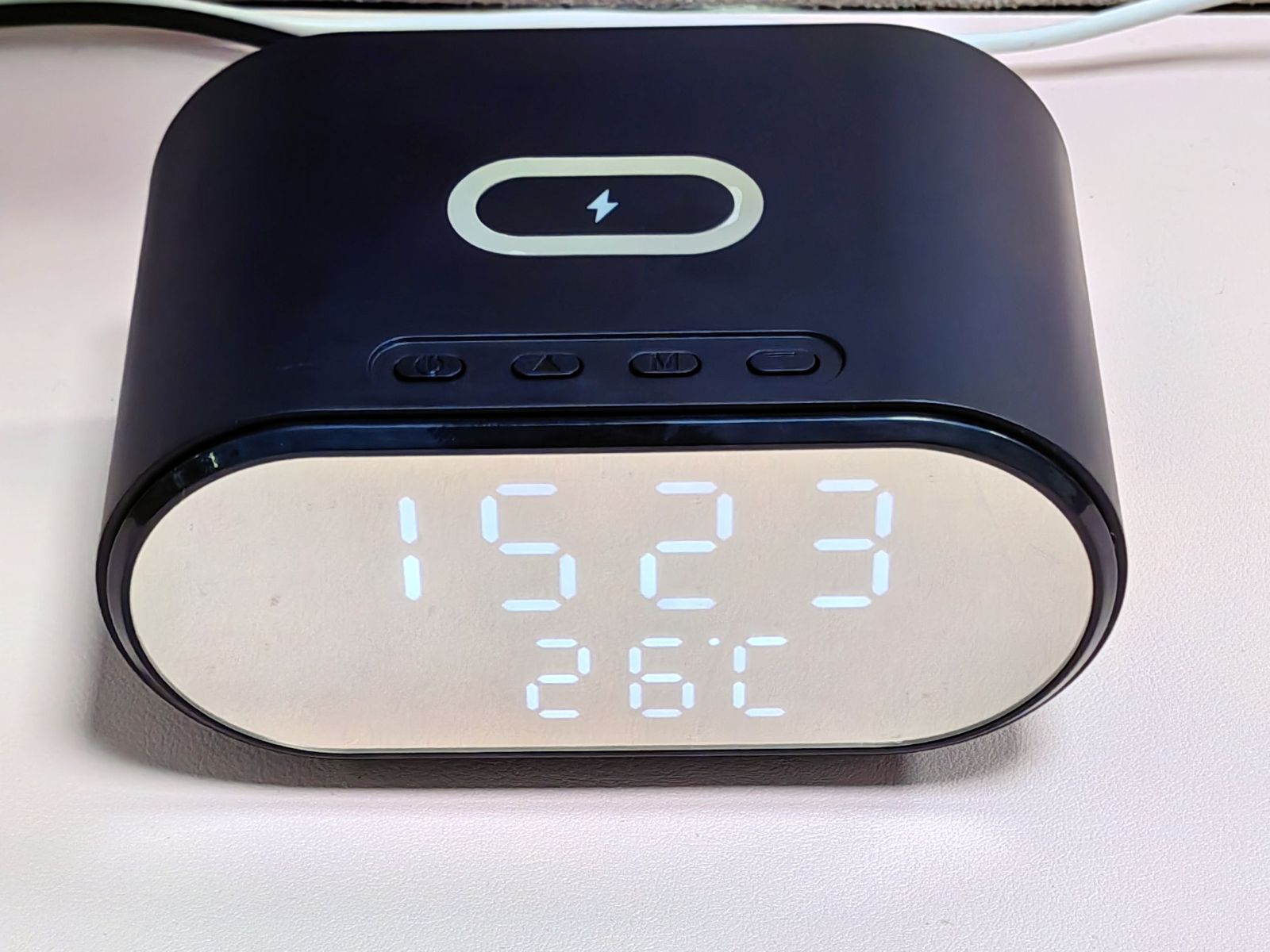 Schwarze Digitaluhr mit der Uhrzeit 15:23 und der Temperatur 26°C.