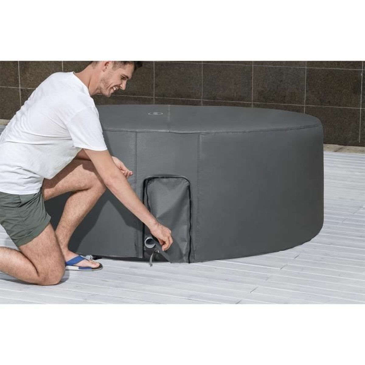 Mann in der Nähe eines grauen Whirlpools auf einer gepflasterten Oberfläche.