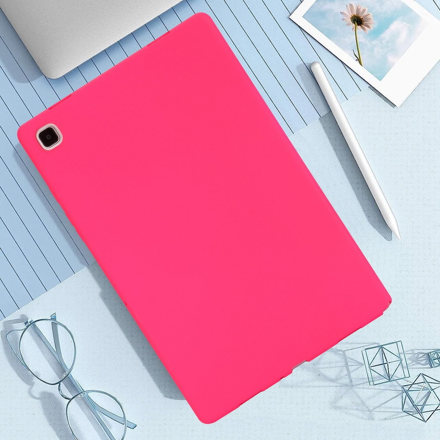 Ein pinkfarbenes Tablet mit Stift auf blauem Hintergrund mit geometrischen Formen und einem Laptop.