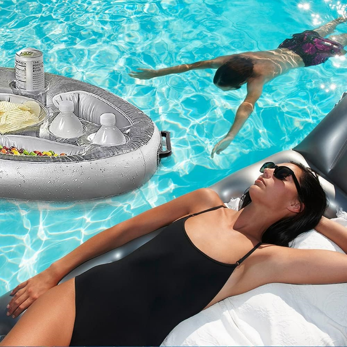 Eine Frau sonnt sich auf einem Float in einem Pool. Ein Mann schwimmt im Hintergrund.