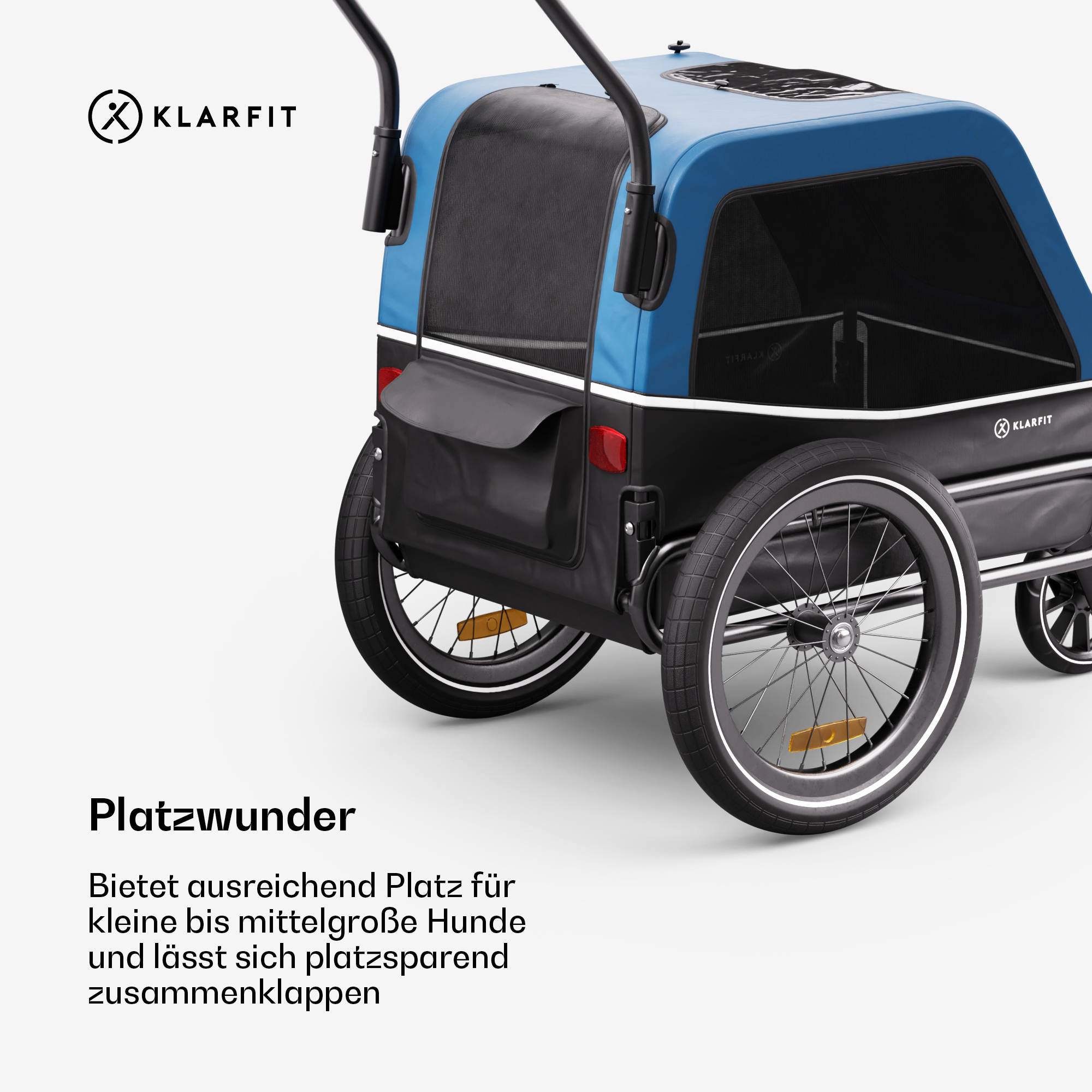 Blau-schwarzer Haustieranhänger. Schwarze Räder, Seitentasche und Klarfit-Logo. Deutscher Text wirbt für Platz für kleine bis mittelgroße Hunde.