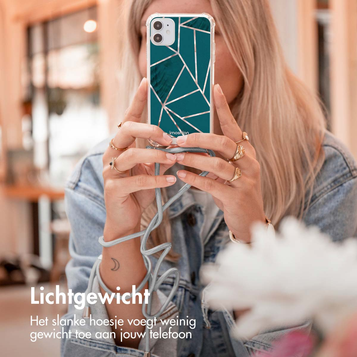 Een vrouw die een telefoon vasthoudt met een hoesje met patroon, die het ontwerp van de telefoon laat zien.