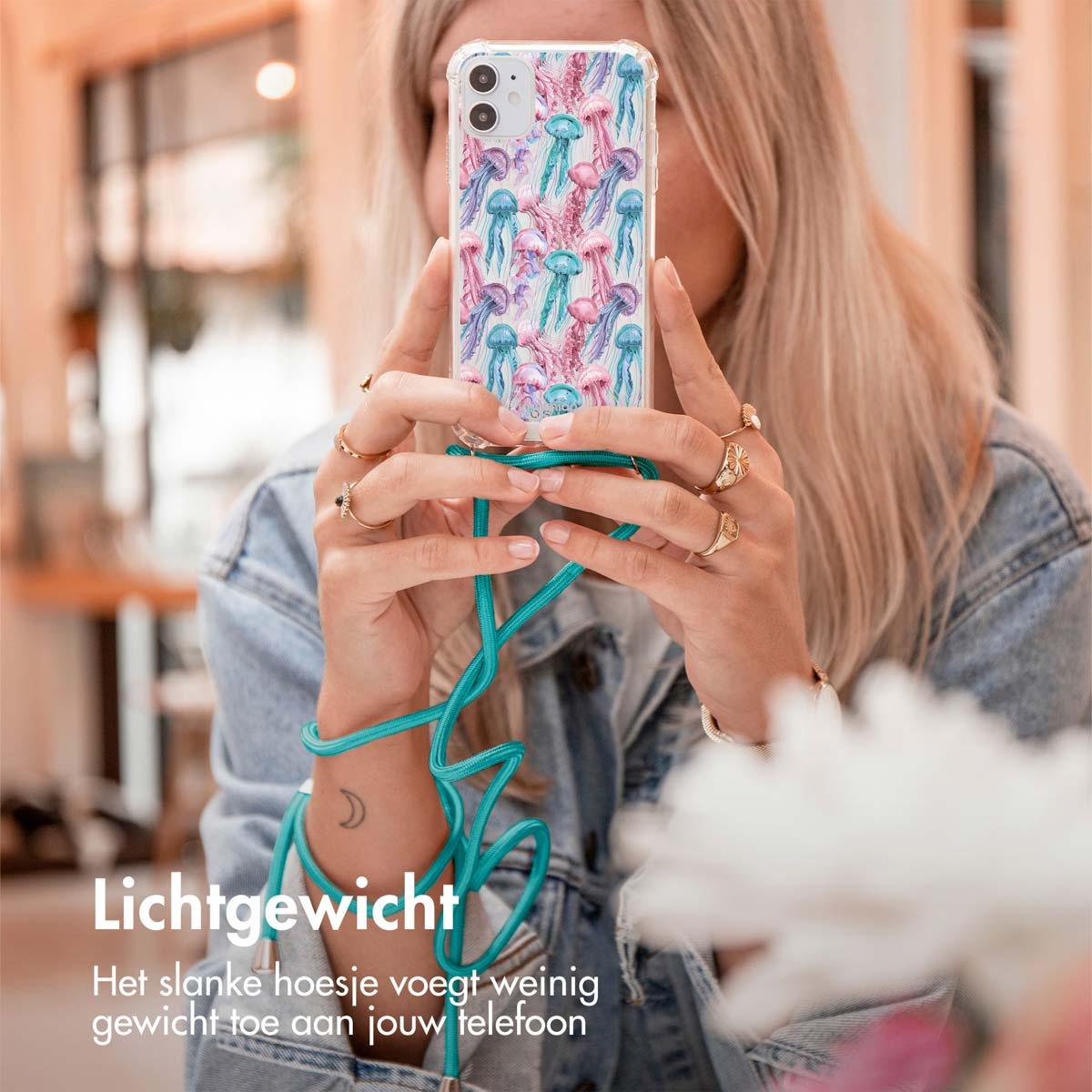 Vrouw die een telefoonhoesje met kwallendesign vasthoudt.
