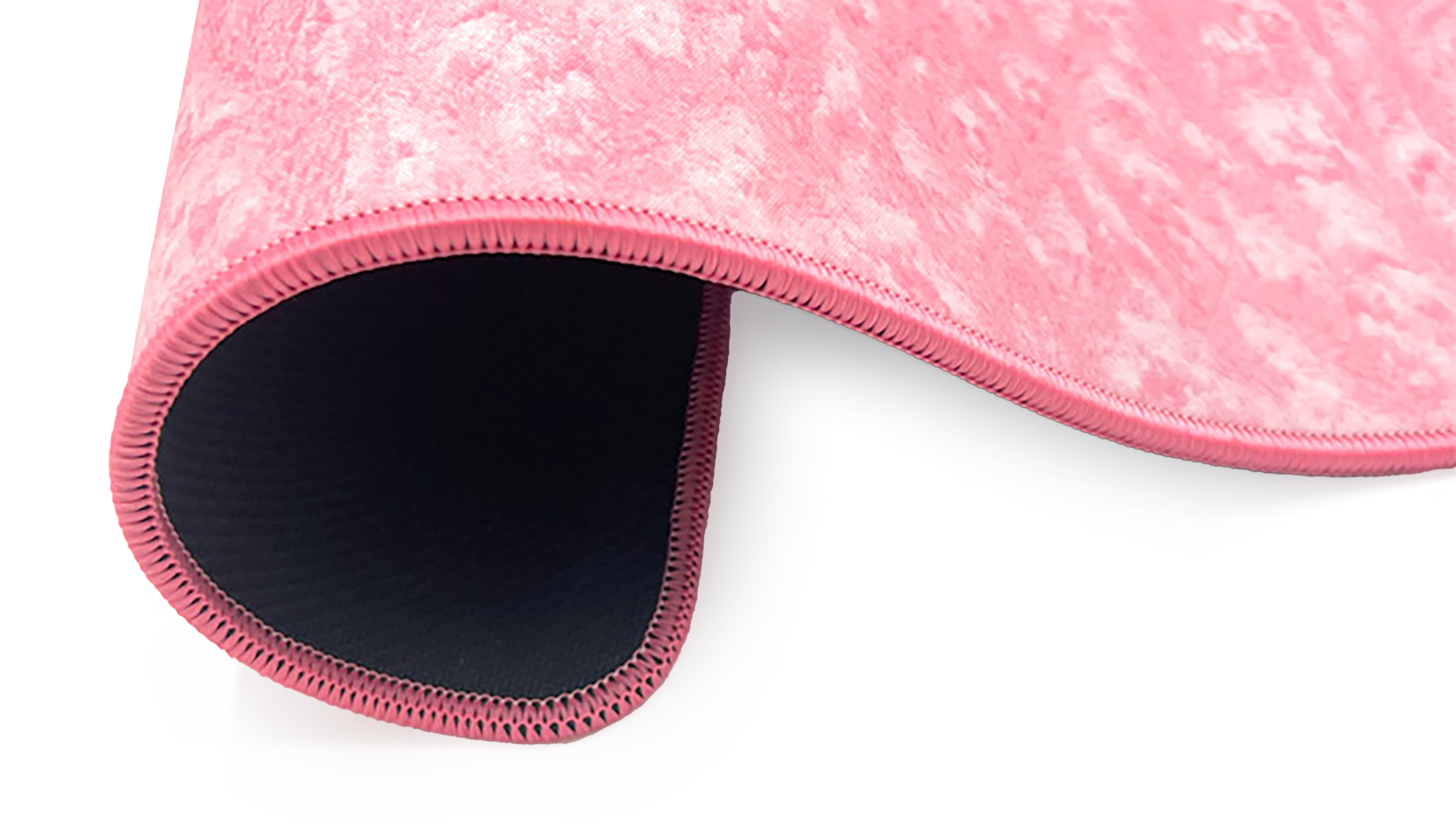 Pink, textured mousepad. The edges are stitched and the back is black. White background.