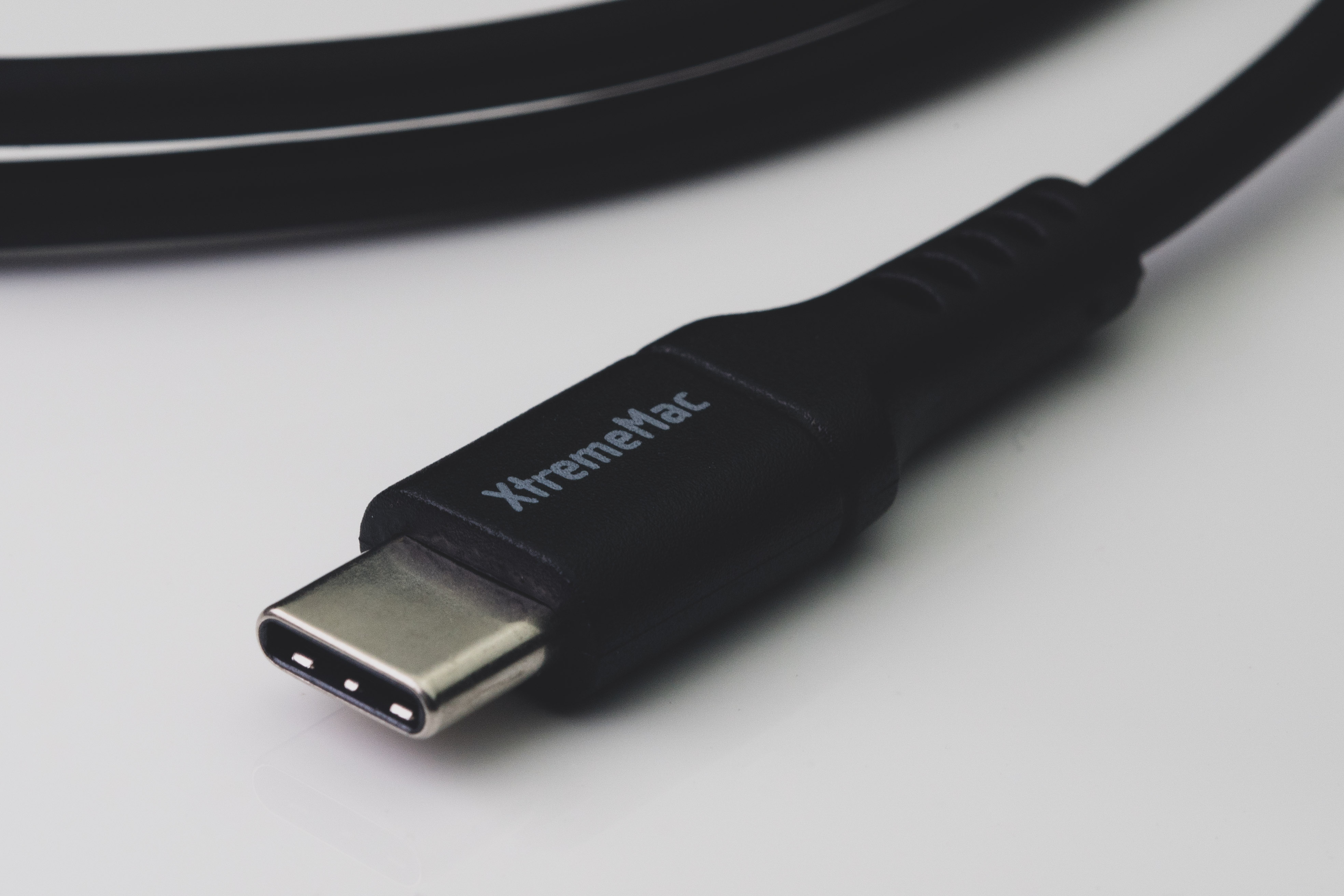 Zwarte USB-C-kabel met 'XtremeMac' tekst, geïsoleerd op witte achtergrond.