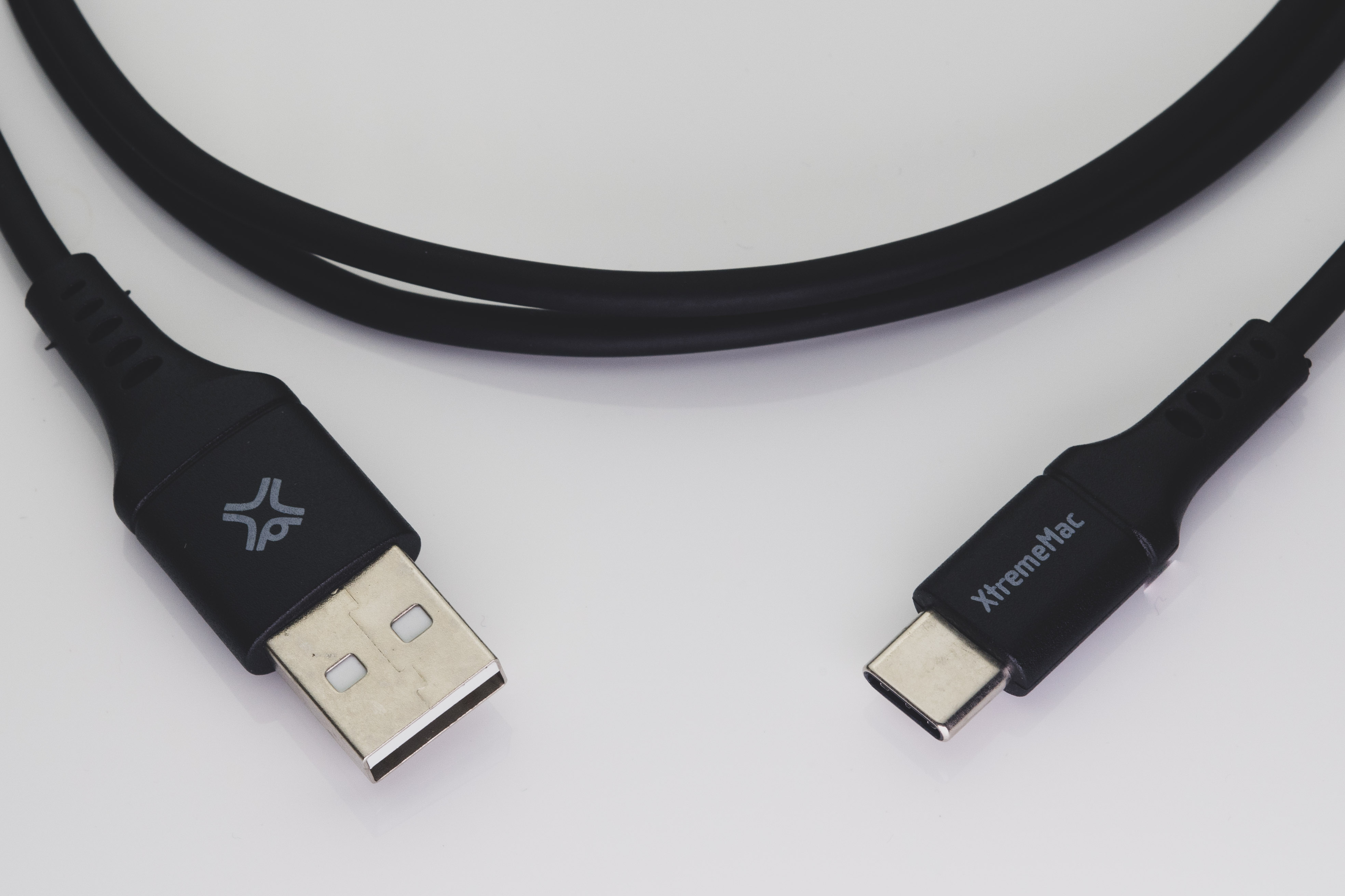 Een close-up van een zwarte USB naar USB-C kabel op een wit oppervlak. XtremeMac logo zichtbaar.