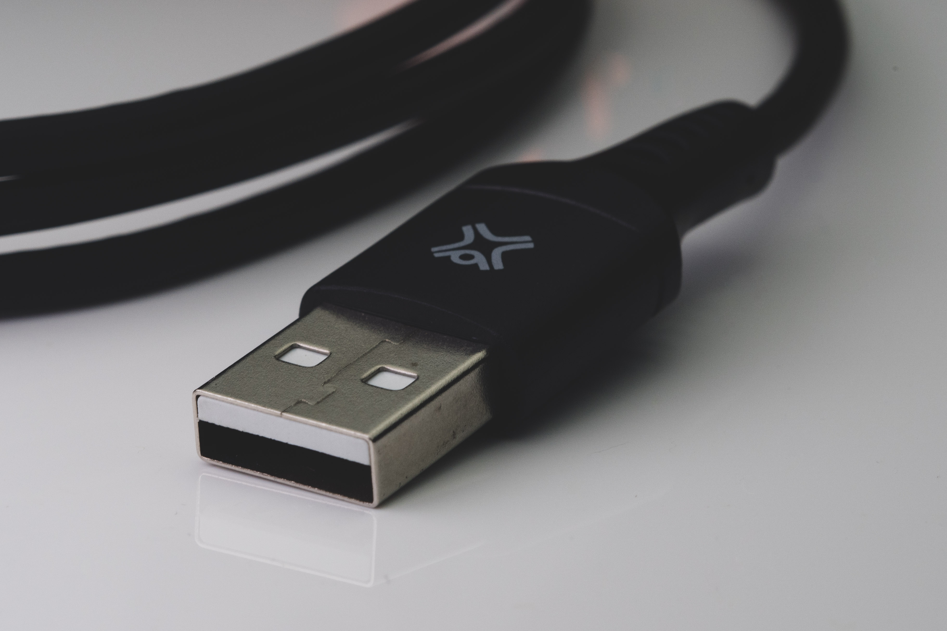 Zwarte USB-kabel met USB-connector, close-up. Witte achtergrond.