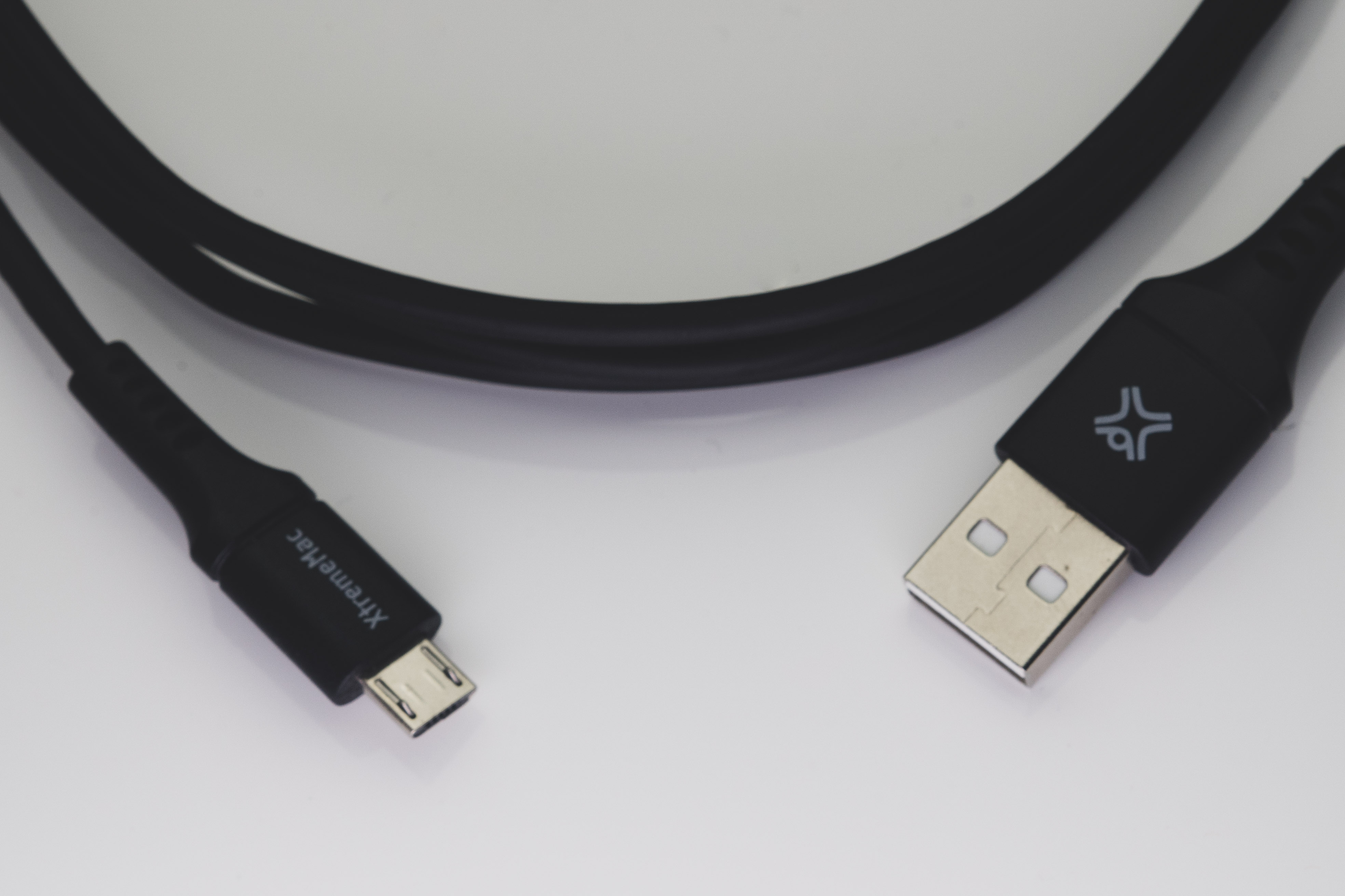 Zwarte USB-kabel met micro-USB en USB-poort op witte achtergrond.
