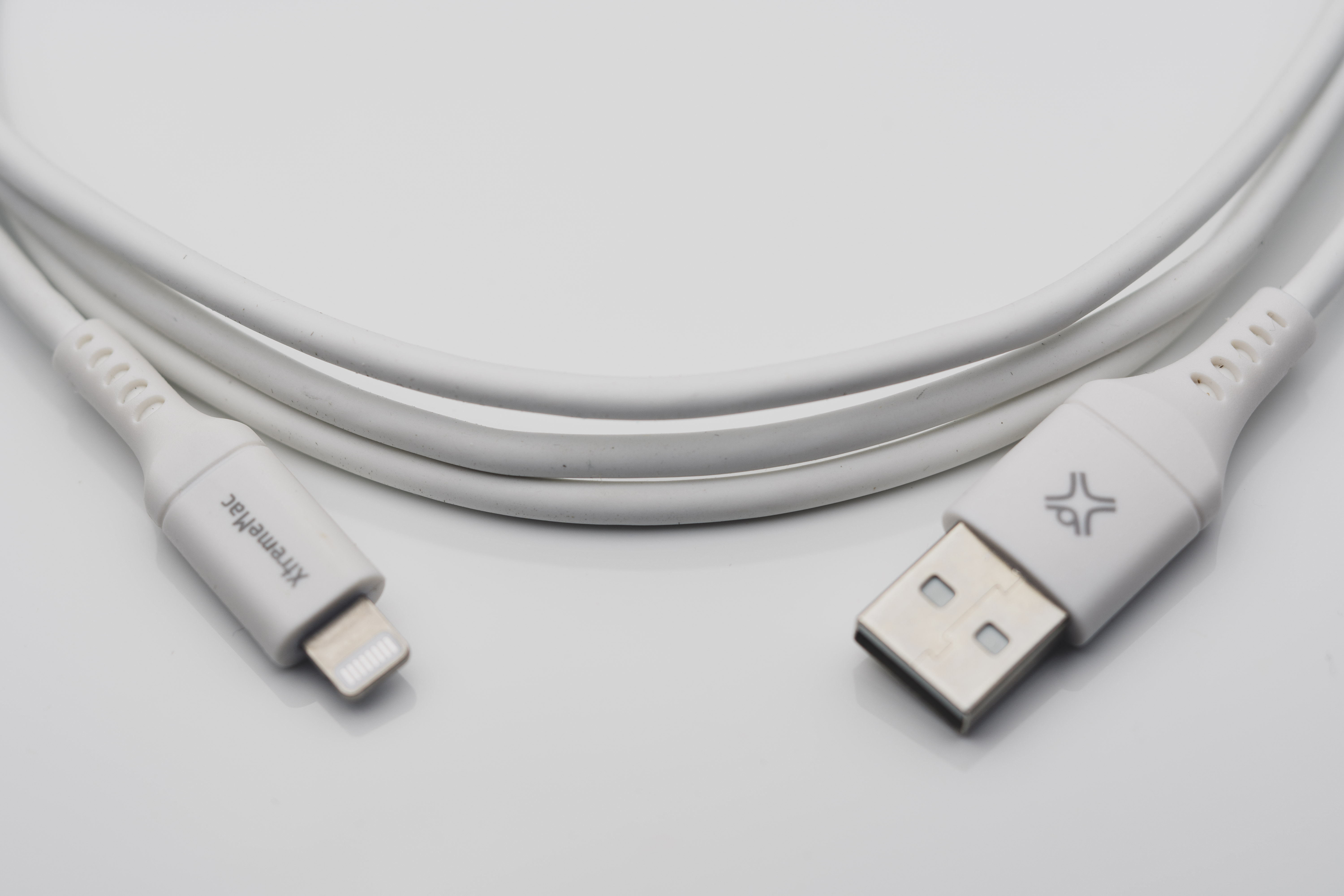 Witte kabel met een lightning-connector en een USB-connector. De merknaam is zichtbaar.