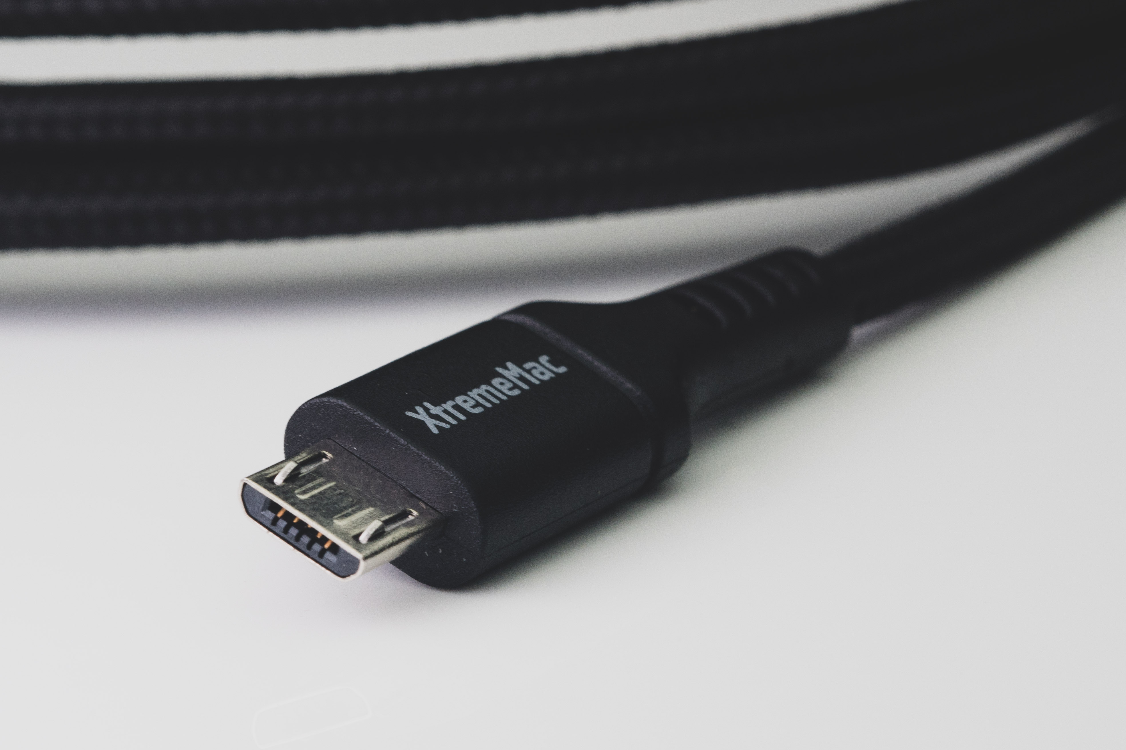 Close-up van een zwarte XtremeMac USB-kabel met een micro-USB-connector.