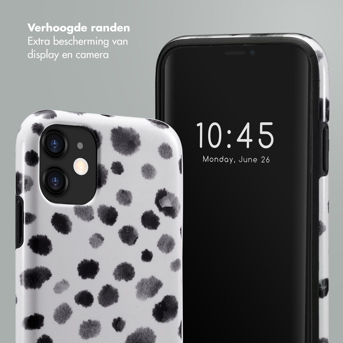 Téléphone dans une coque à pois dalmatiens noir et blanc. Téléphone noir avec l'heure affichée.