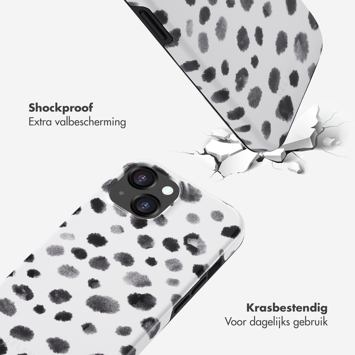 Une coque de téléphone à pois noirs. La coque est fissurée. Une autre coque tombe. Fond blanc.