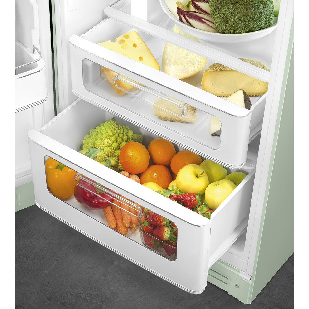 Interior de refrigerador con cajones llenos de frutas, verduras y queso. Colores blanco y verde claro.