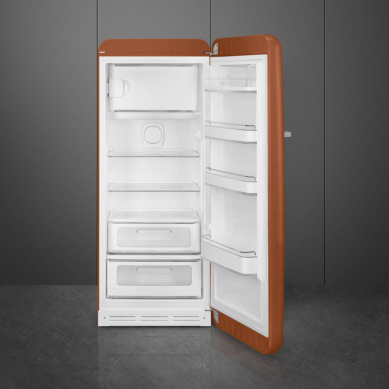 Frigorifero retrò arancione con la porta aperta. Interno con ripiani e cassetti.