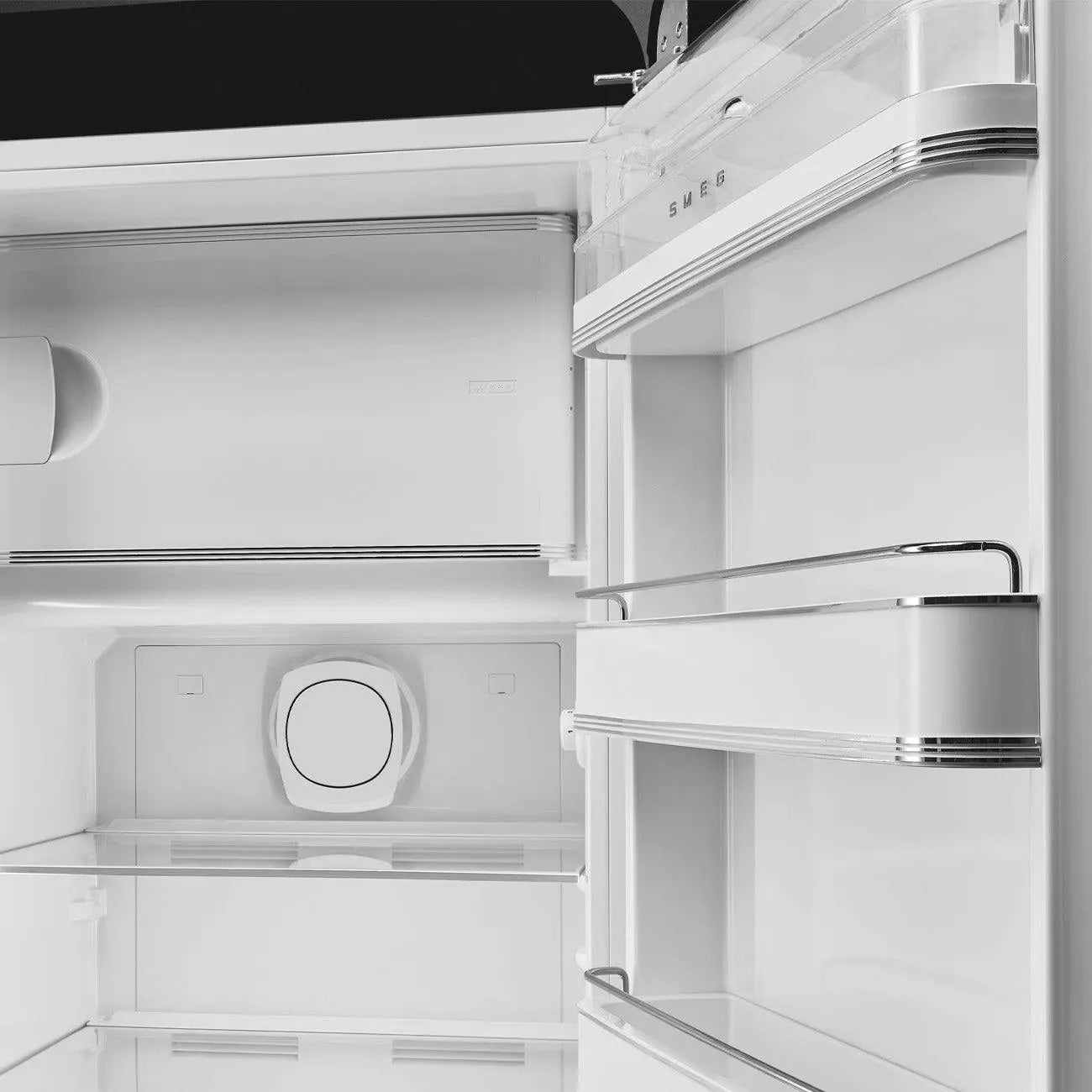 Das Innere eines weißen SMEG-Kühlschranks. Es gibt Regale, Schubladen und die Marke SMEG ist sichtbar.