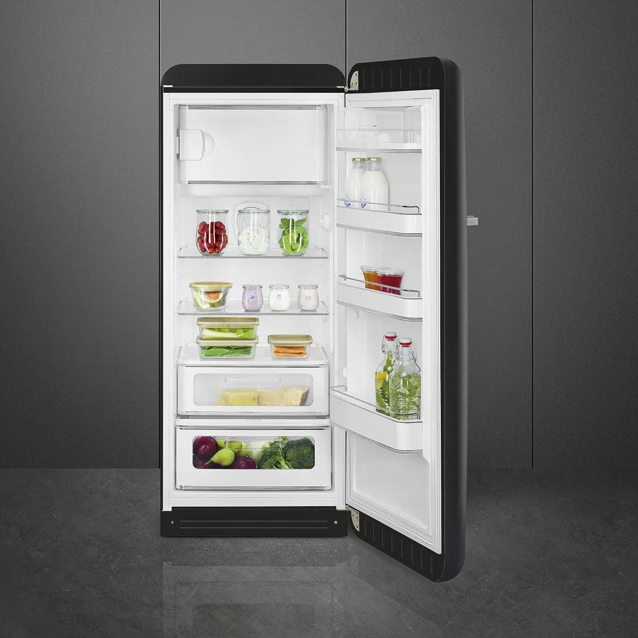 Un refrigerador Smeg negro con la puerta abierta, mostrando estantes con alimentos.