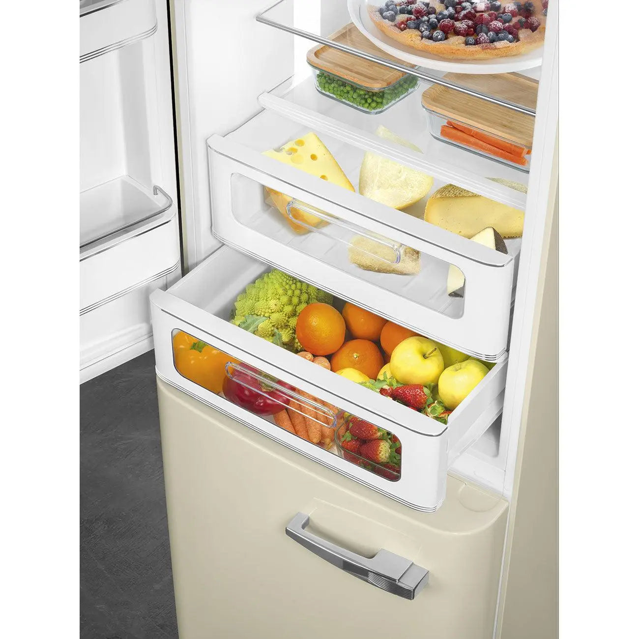 Primer plano de un refrigerador con cajones llenos de frutas, verduras y queso, y recipientes de vidrio.