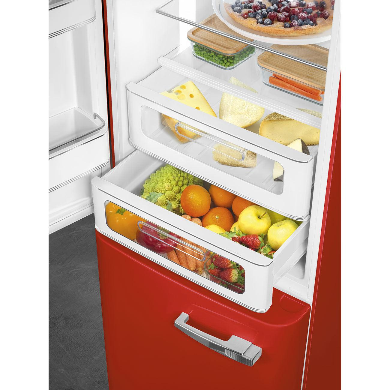 Interior del refrigerador con cajones de comida. Se ven queso, verduras, frutas.