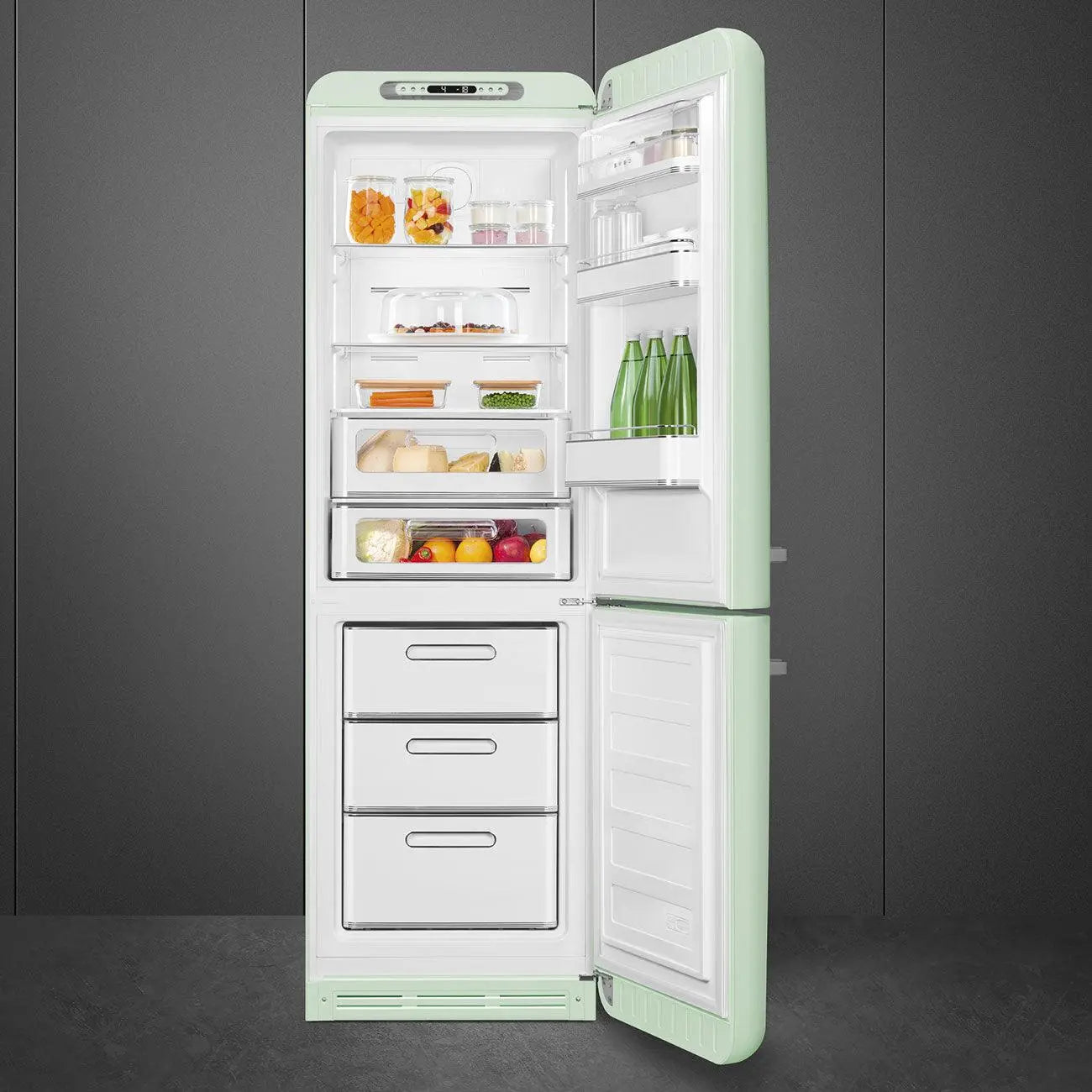 Refrigerador verde abierto con estantes de alimentos, incluyendo cajones, sobre fondo gris.