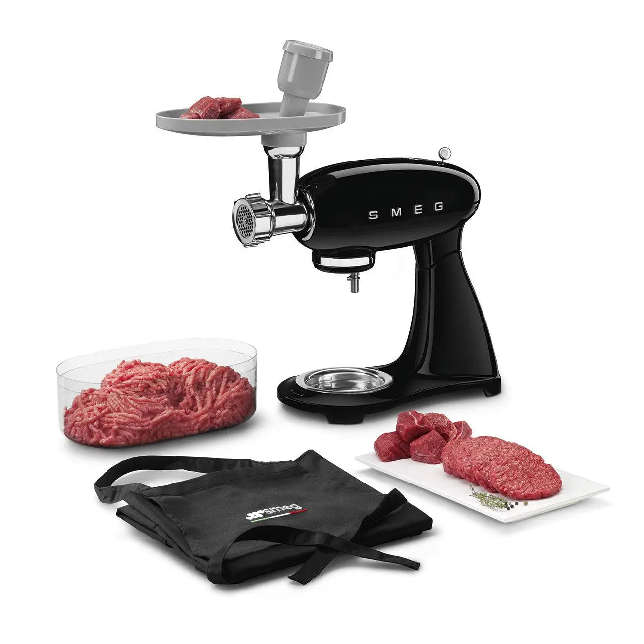 Schwarzer SMEG Fleischwolf mit Fleisch und Zubehör auf weißer Oberfläche.