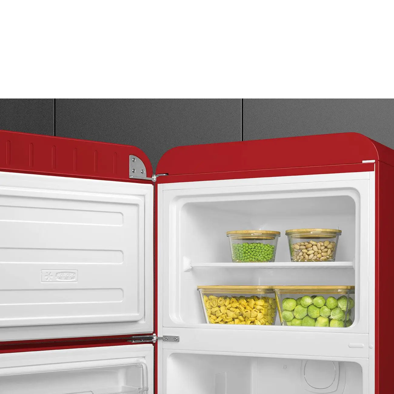 Interior de refrigerador rojo con puerta abierta. Contiene recipientes de comida verde y amarilla.