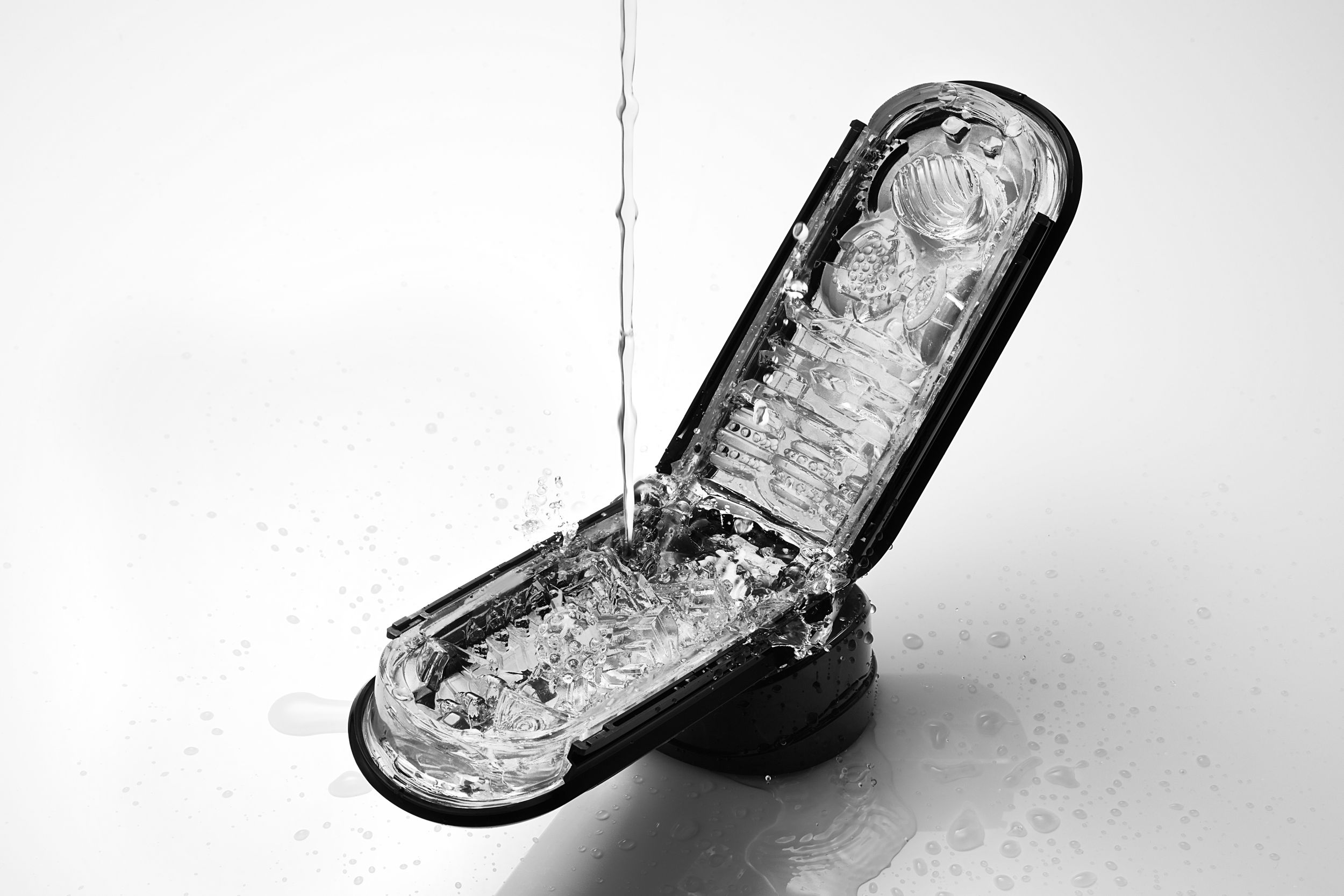 Czarne i przezroczyste plastikowe urządzenie, do którego wlewana jest woda.