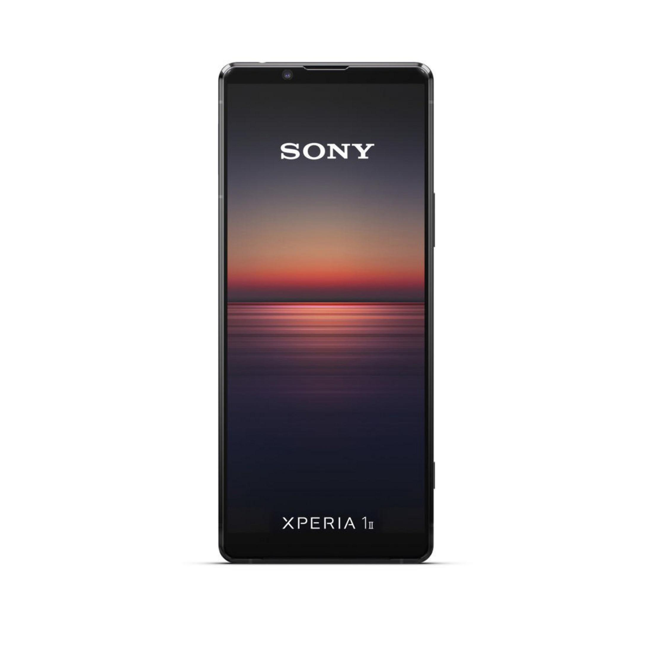 Smartphone mit Sony-Logo auf dunklem Hintergrund mit Sonnenuntergang über Wasser.
