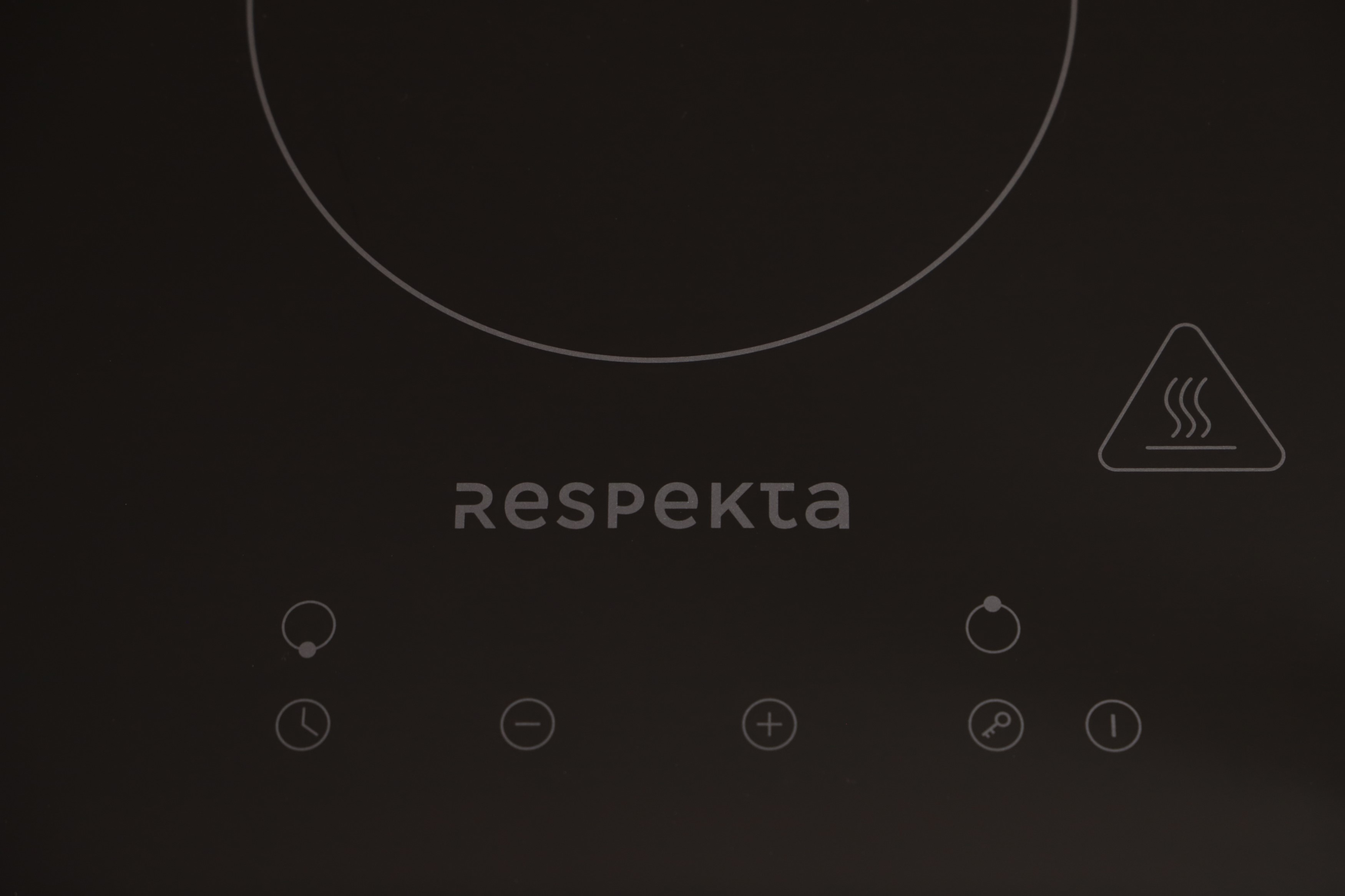 Black induction cooktop with Respekta logo and control panel. Warning sign.