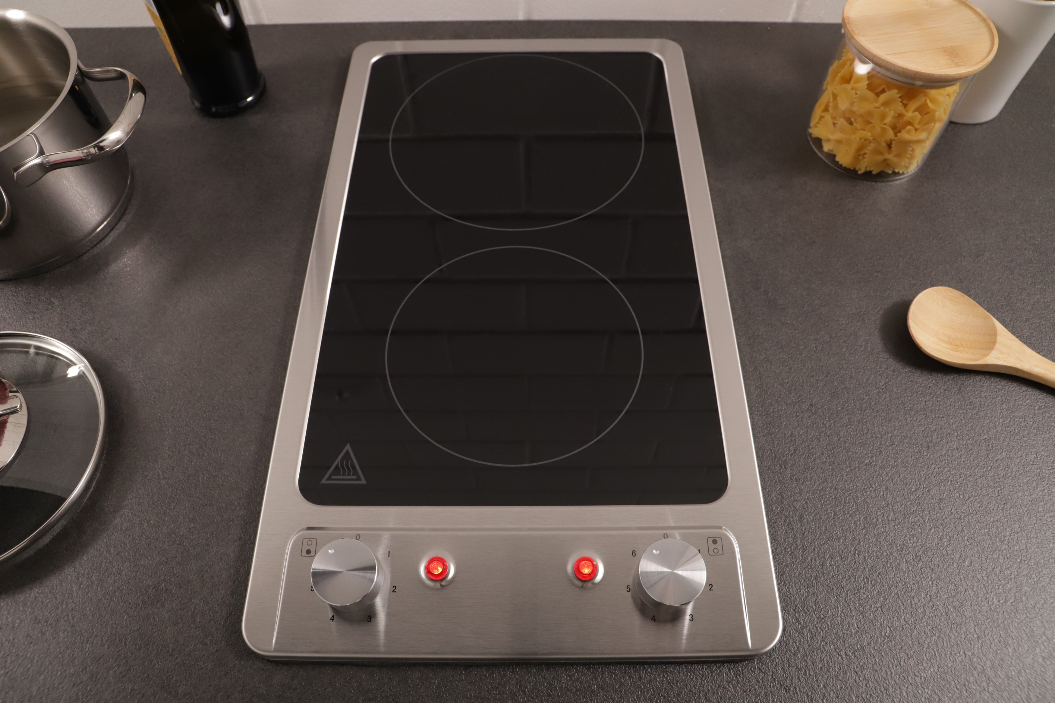 A two-burner induction cooktop on a kitchen counter with other items.