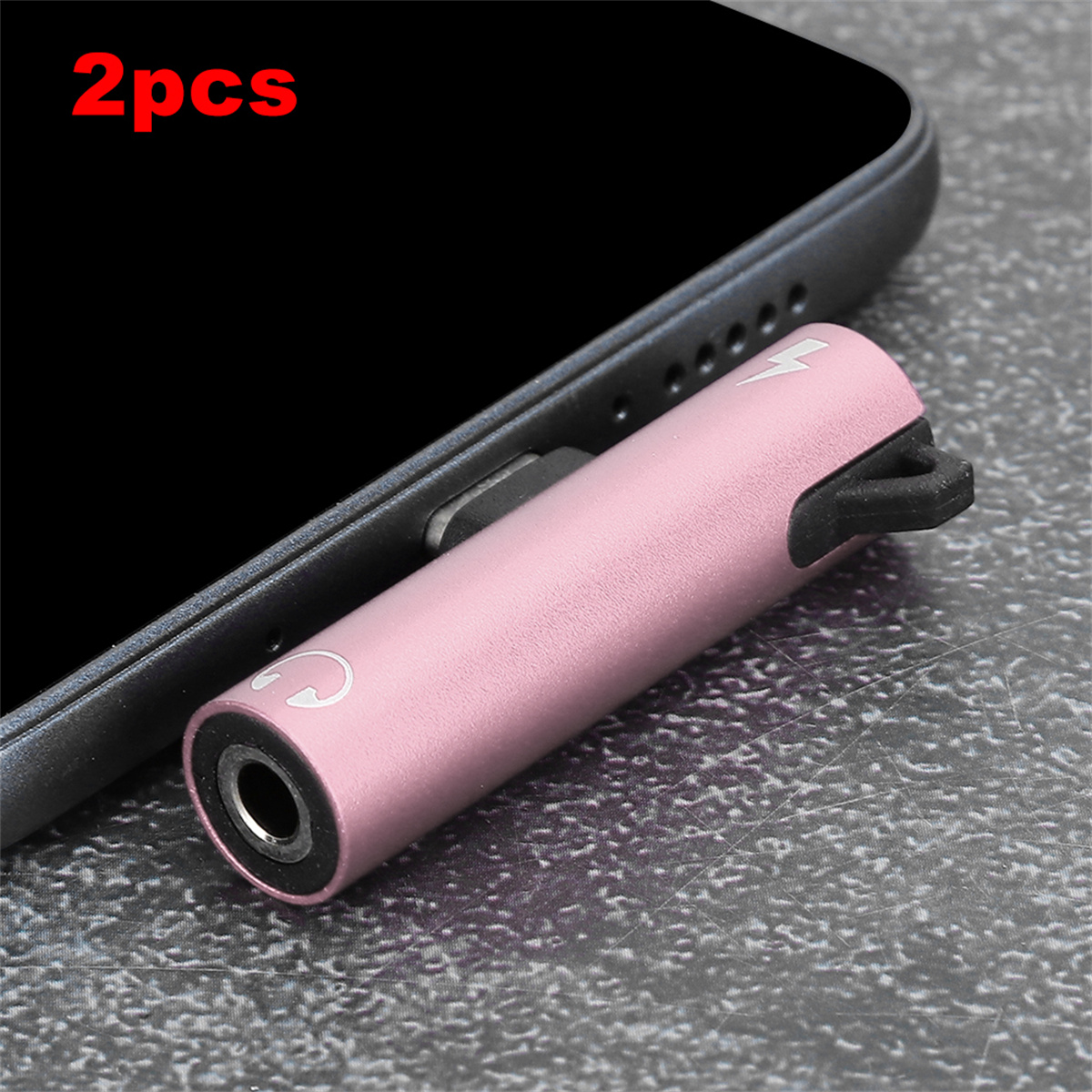 Zwei rosa Adapter für ein Telefon. Ein Ende ist ein Ladeanschluss und das andere ein Kopfhöreranschluss.
