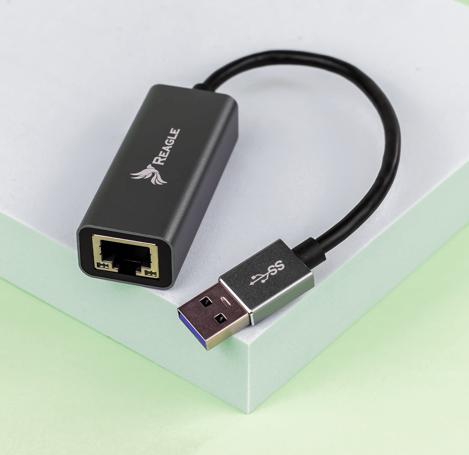 Adapter USB na Ethernet na zielono-białej powierzchni.