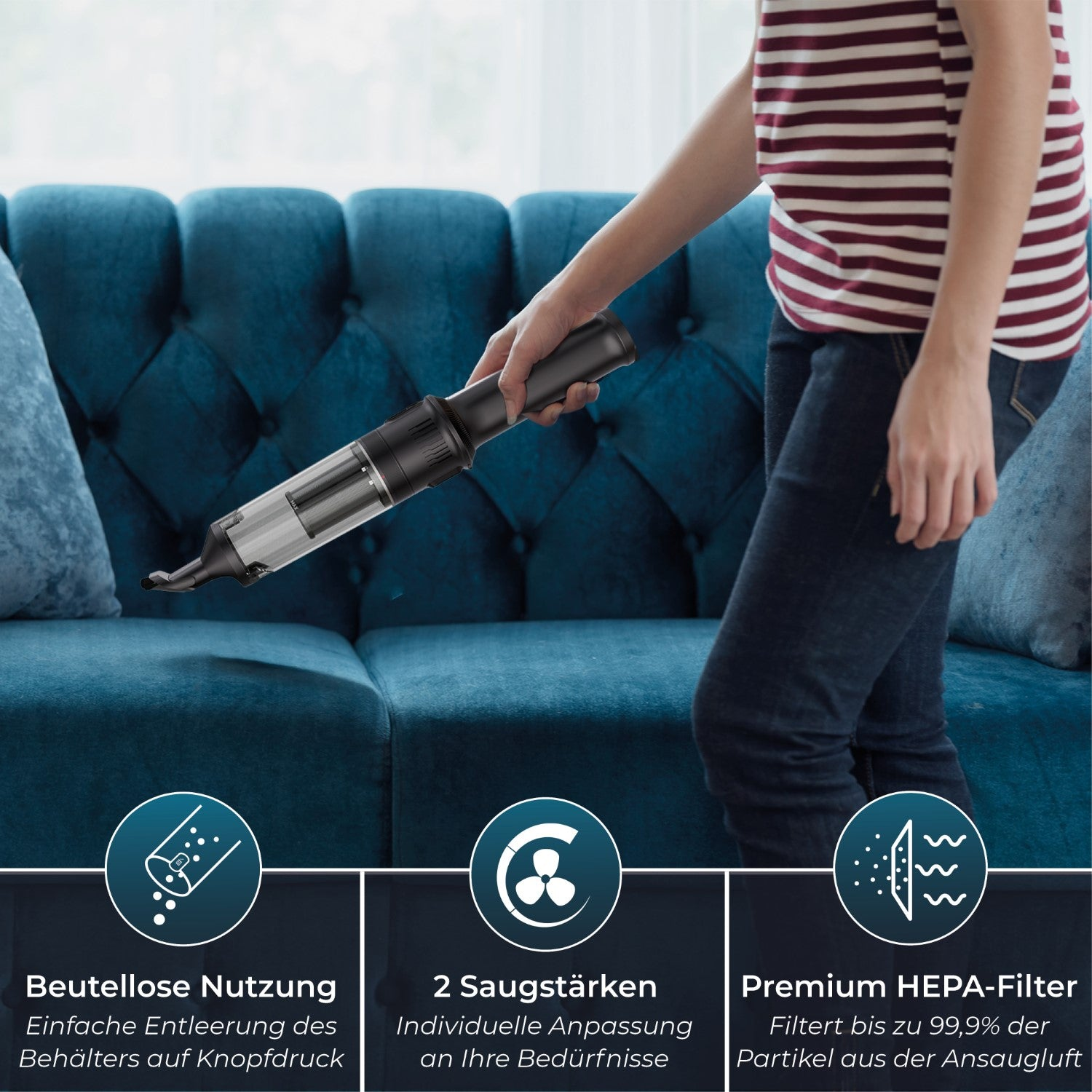 Eine Person benutzt einen Handstaubsauger auf einem blauen Sofa.