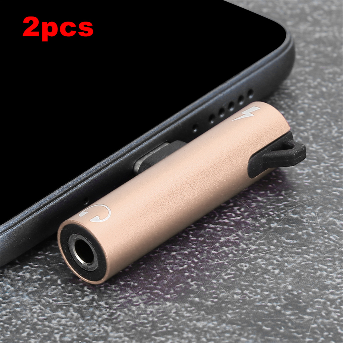 Ein goldener Adapter, der in ein Telefon eingesteckt ist, mit Kopfhöreranschluss.