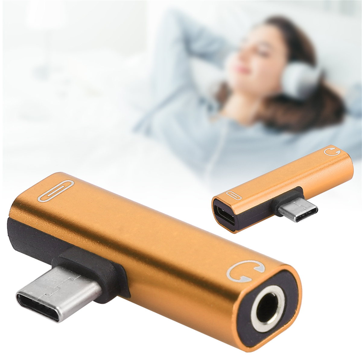 Goldener USB-C-Audioadapter mit zwei Anschlüssen, verschwommener Hintergrund.