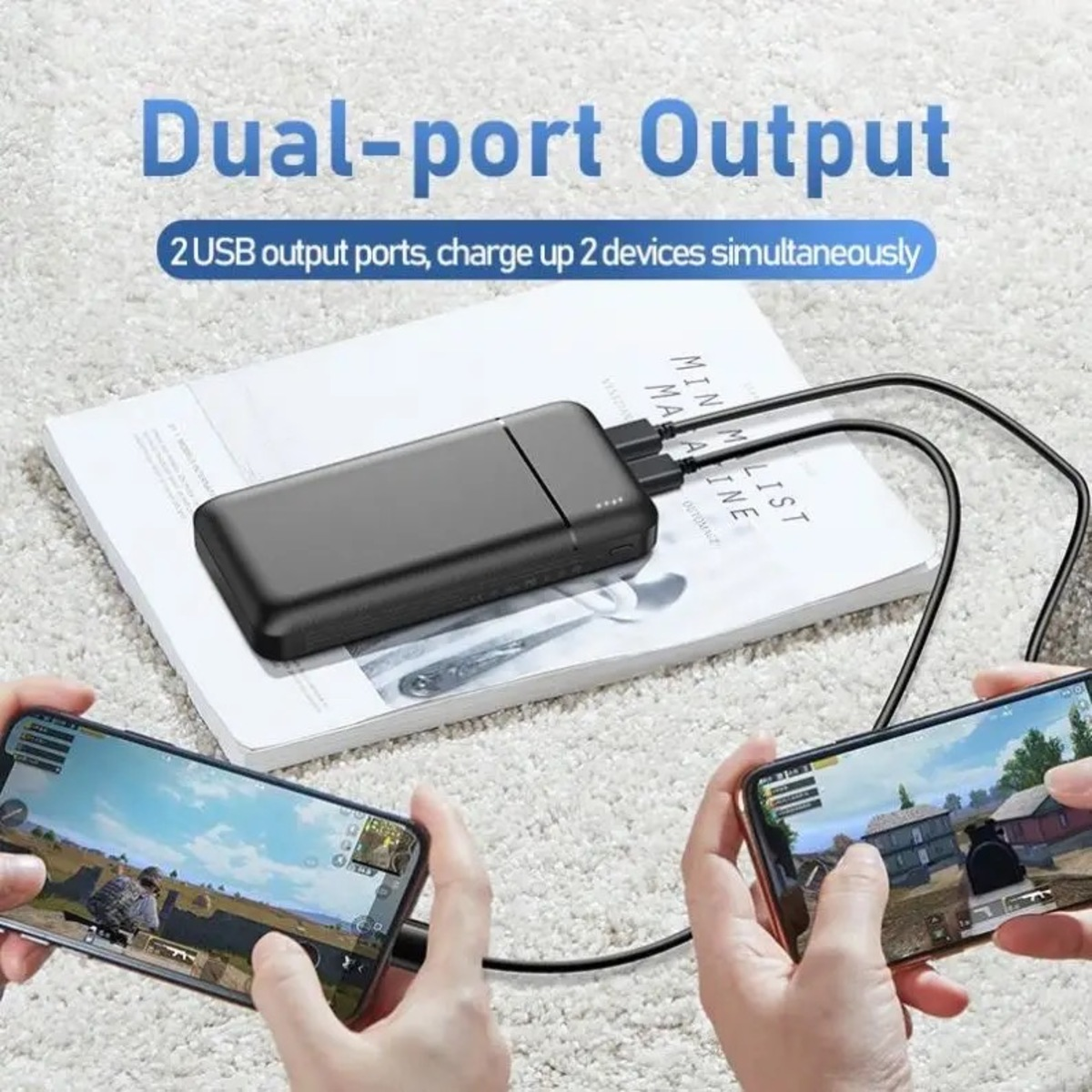 Schwarze Powerbank, die zwei Telefone lädt. Eines hat einen Spielbildschirm.