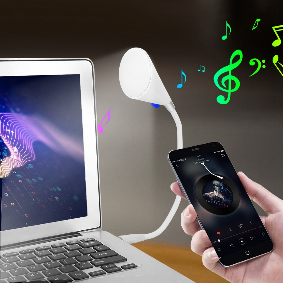 Laptop mit angeschlossener weißer Leuchte, Smartphone mit Musik-Oberfläche und Noten.