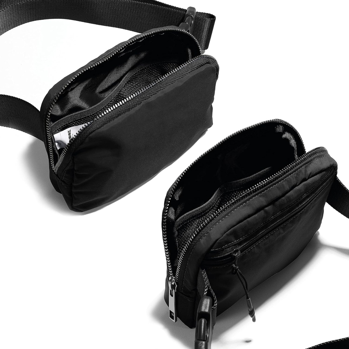 Zwei schwarze Bauchtaschen offen, Fächer zeigend. Weißer Hintergrund.