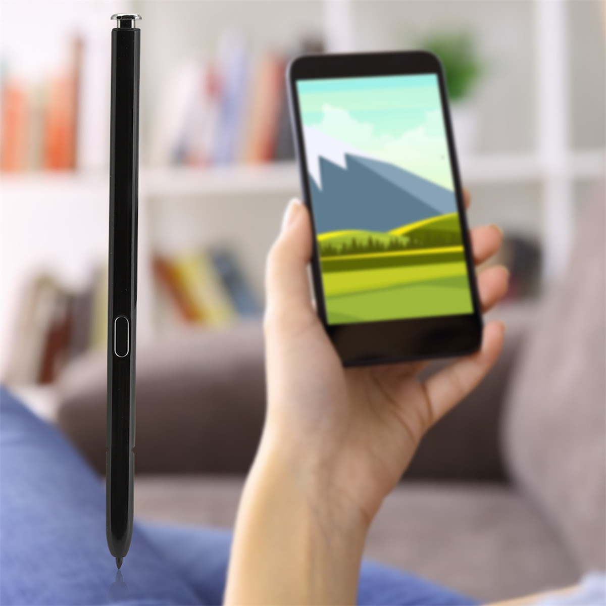 Schwarzer Eingabestift. Eine Person hält ein Telefon. Das Telefon zeigt eine Berglandschaft.