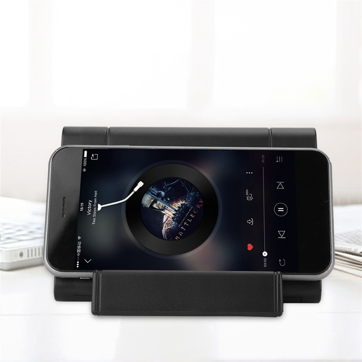 Schwarzes Smartphone auf einem Ständer, das Musik abspielt, mit einer Vinyl-Schallplatte auf dem Bildschirm.