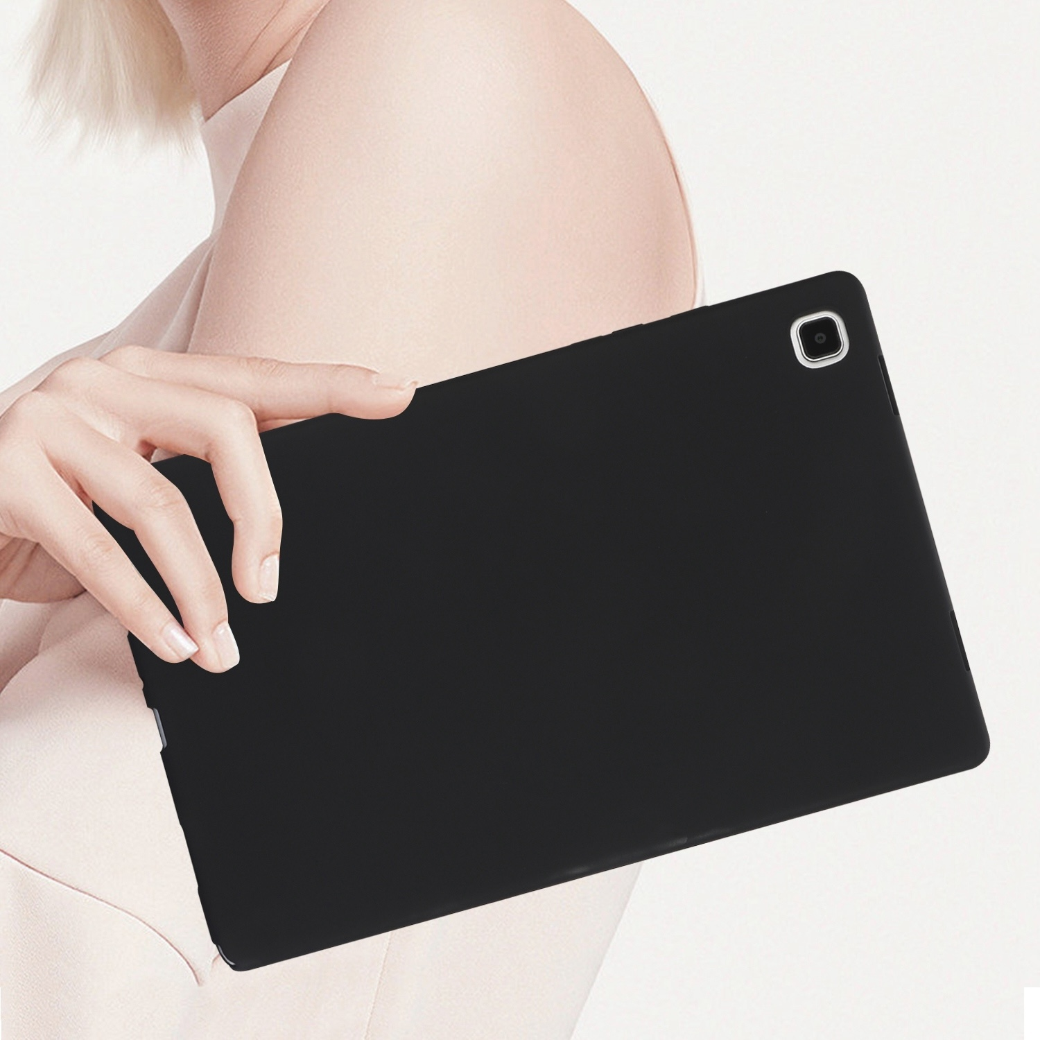 Eine Frau hält ein schwarzes Tablet. Das Tablet ist schwarz. Der Hintergrund ist weiß. Das Tablet hat eine Kamera.